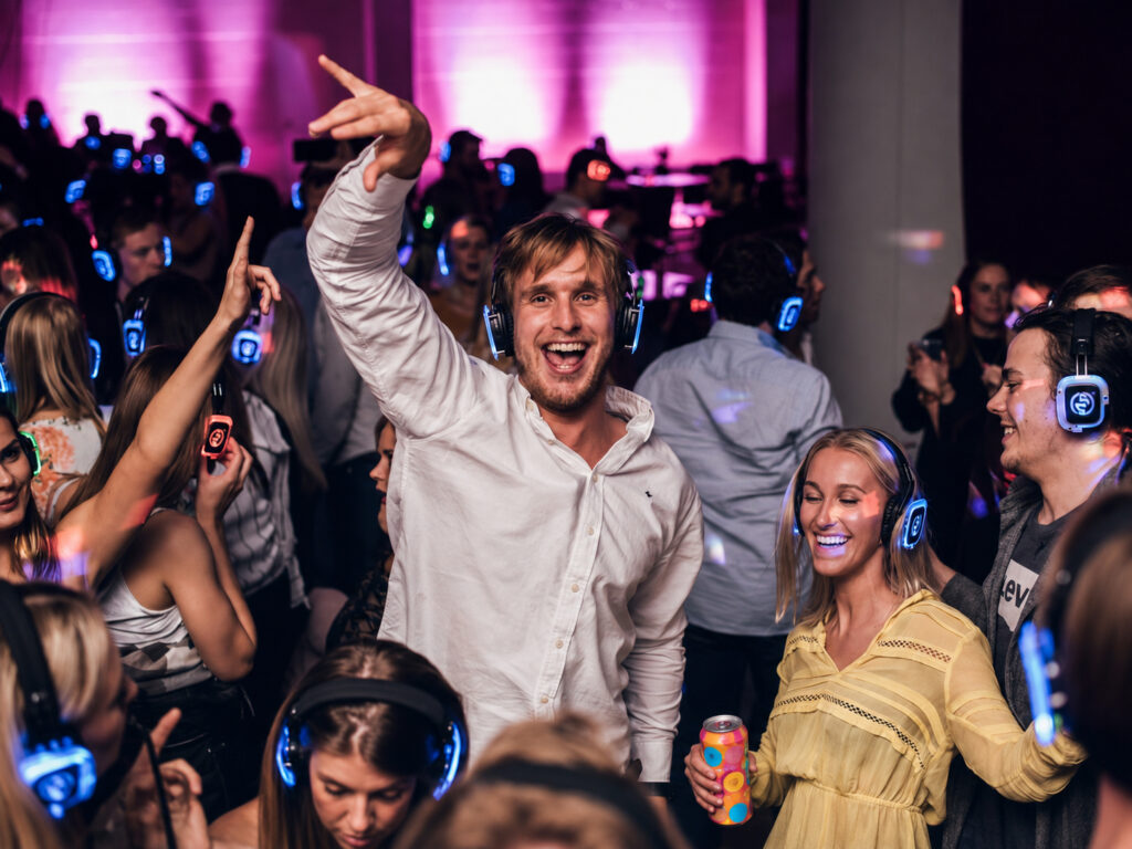 Energetic crowd at party with wireless headphones