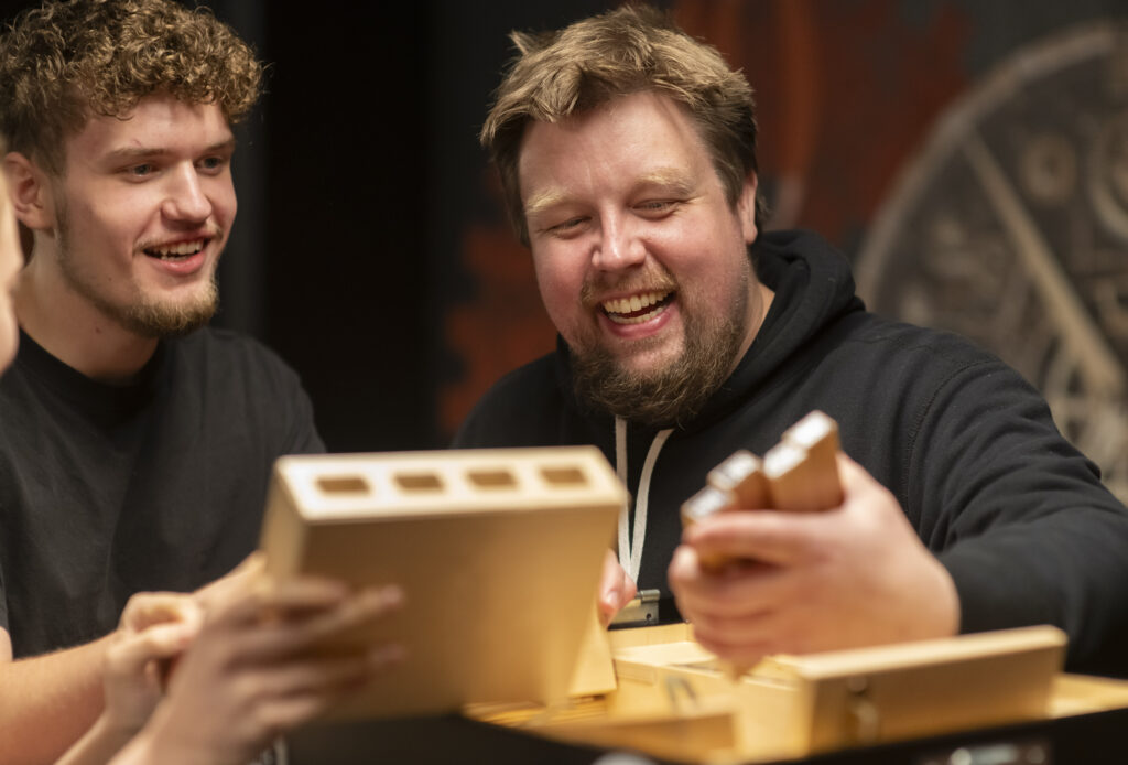 Two friends laugh as they build together