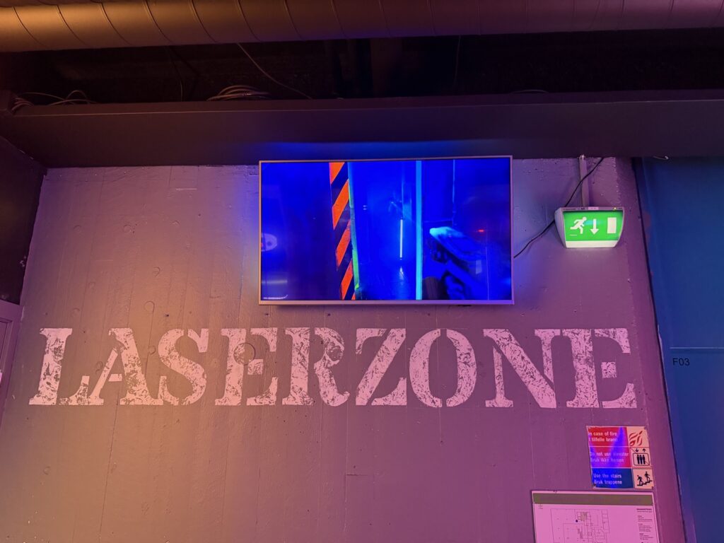 «LASERZONE» sign and screen in the blacklight room
